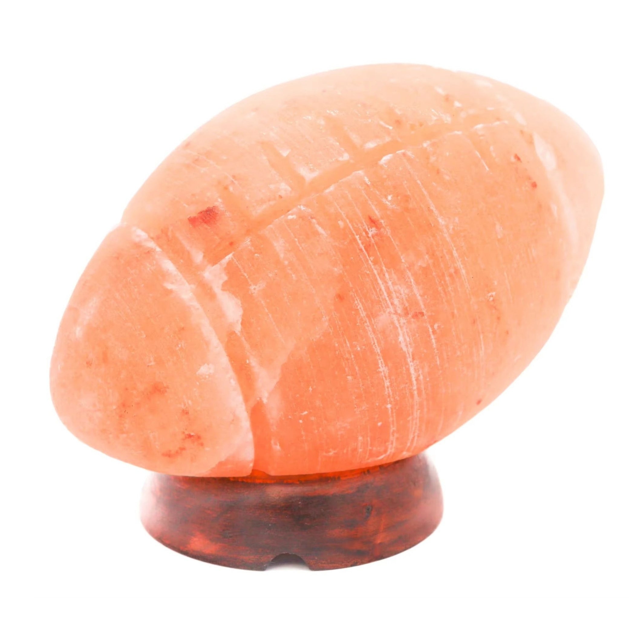 Hand-carved Himalayan salt rugby ball lamp on a wooden base