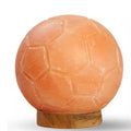 Hand-carved Himalayan salt soccer ball lamp on a wooden base