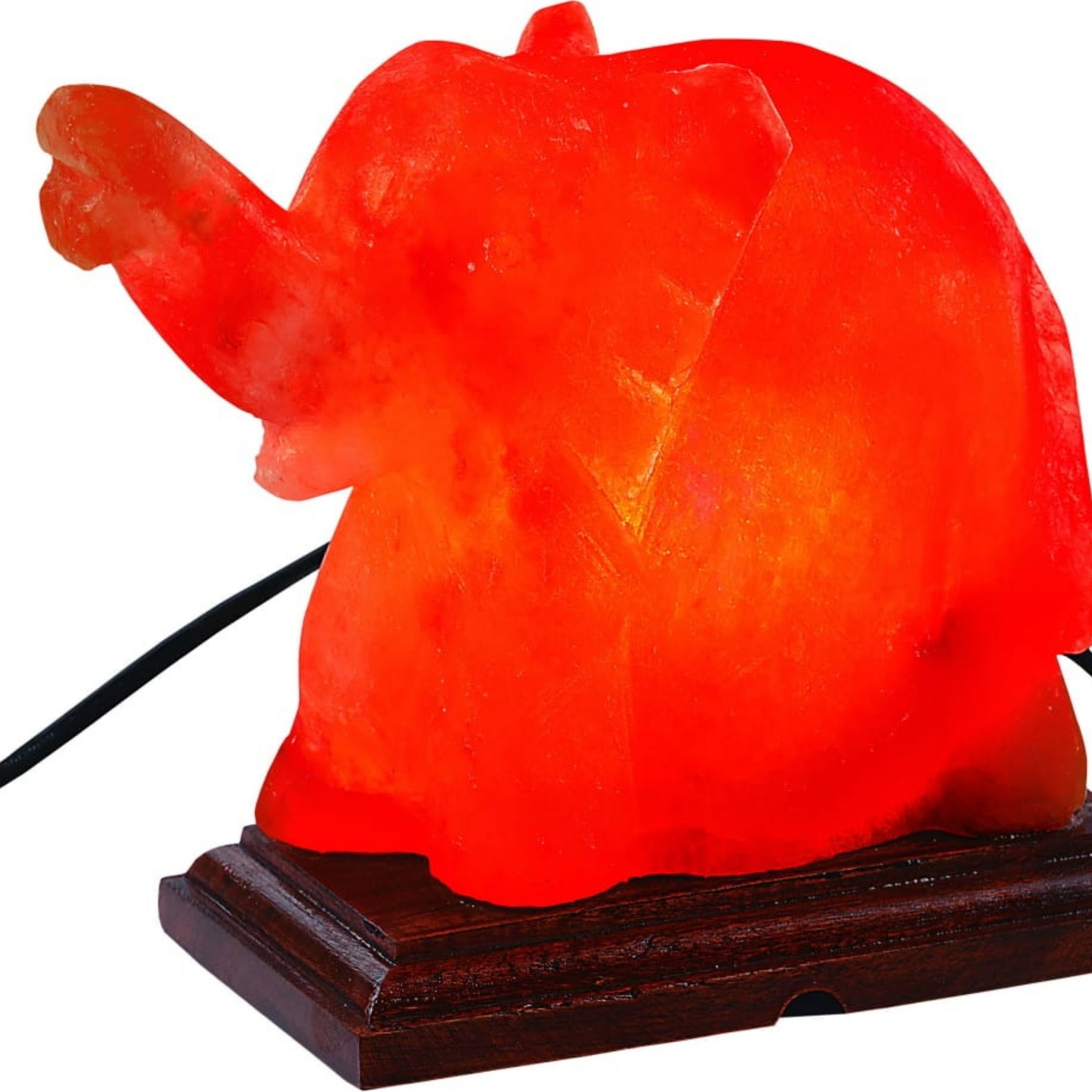 Hand-carved Himalayan salt elephant lamp glowing warm on a wooden base