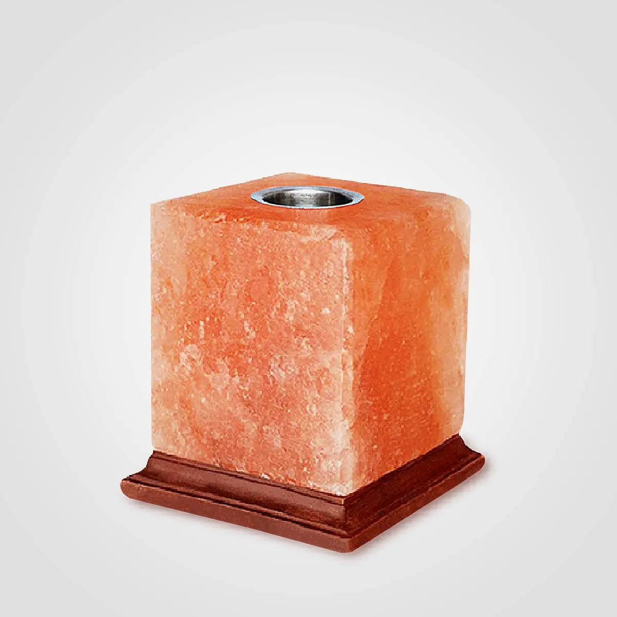 Hand-carved salt oil burner glowing amber with an oil dish