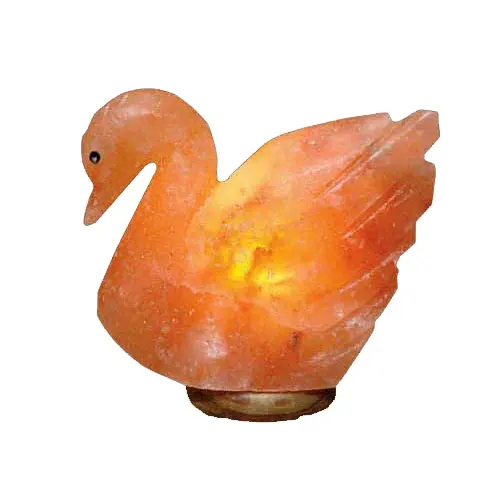 Hand-carved Himalayan salt swan lamp glowing warm amber on a wooden base