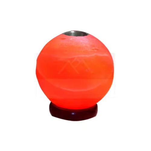 Hand-carved salt ball oil burner glowing amber with an oil dish