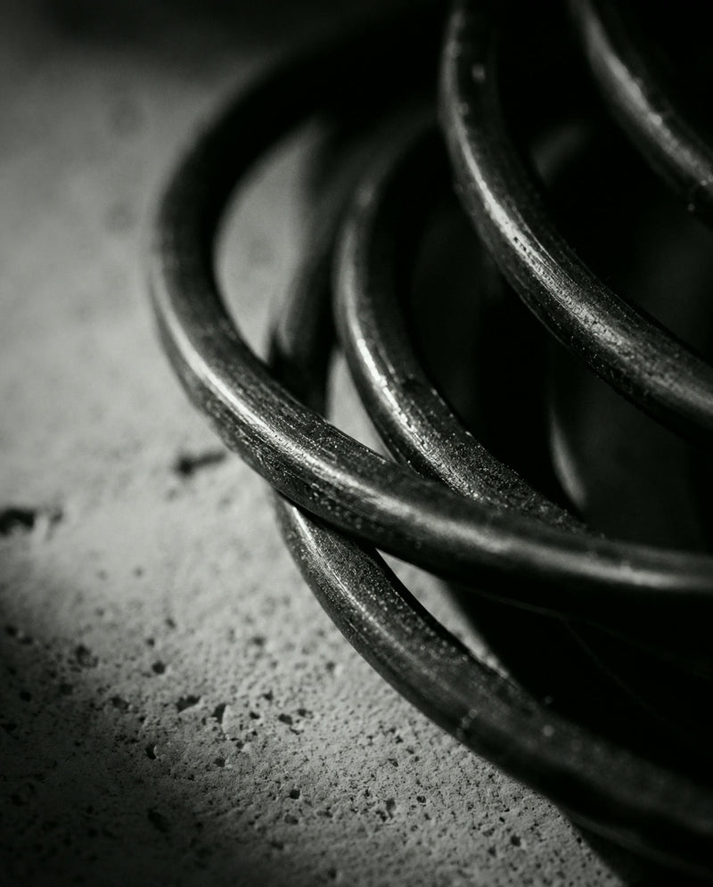 Coiled dark metal wire on pale stone