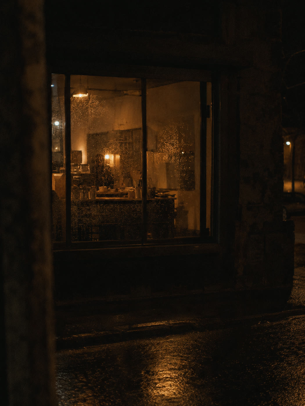 A warmly lit shop window seen from the street at night